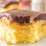 a piece of boston cream poke cake with a bite out
