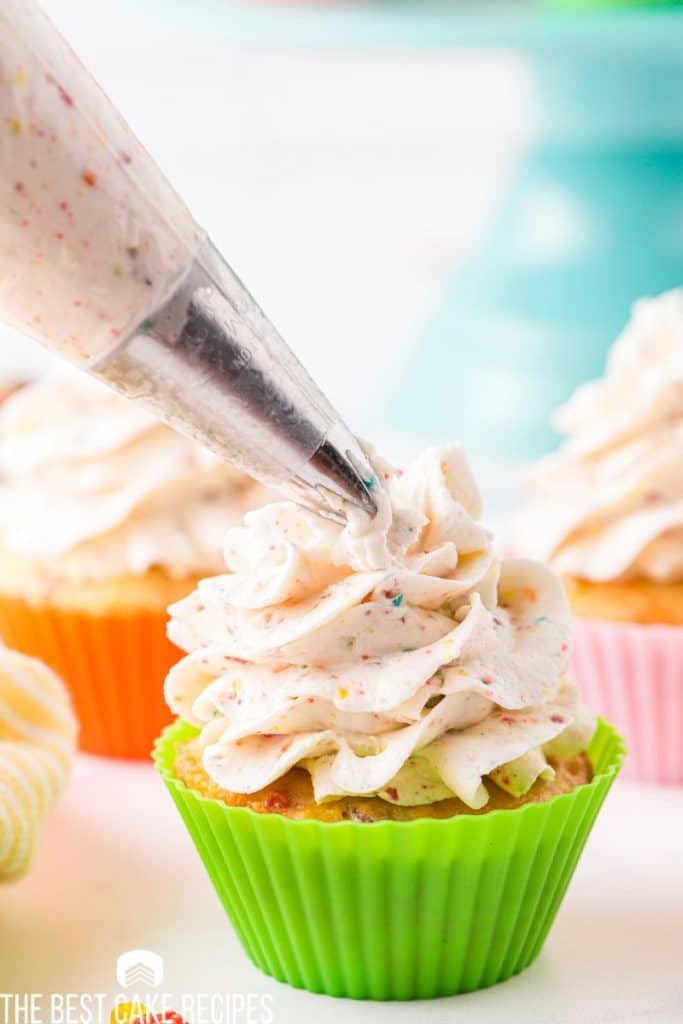 piping frosting onto a cupcake