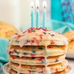 a stack of pancakes with candles on top