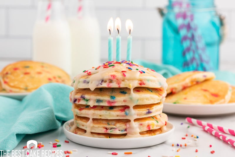 a stack of birthday pancakes with candles