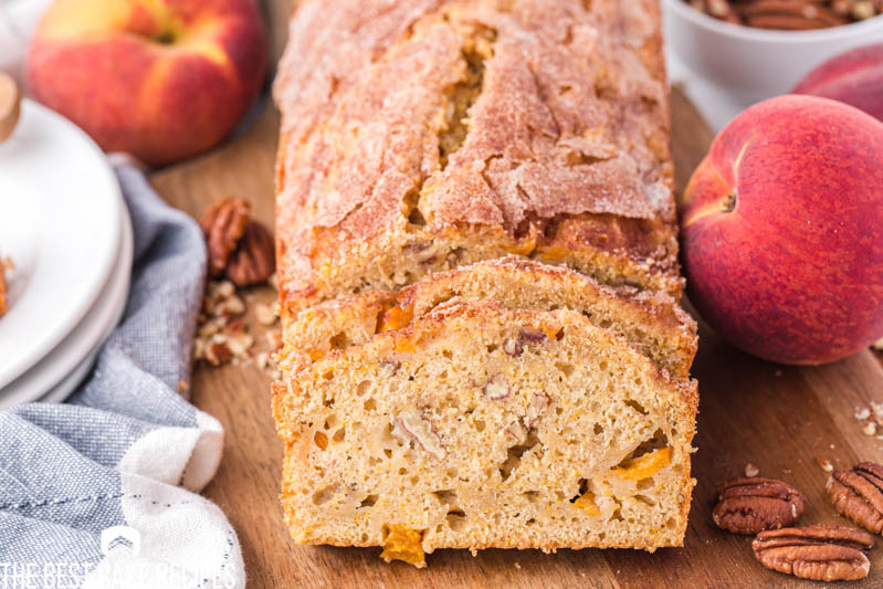 a loaf of peach loaf cake on a cutting board