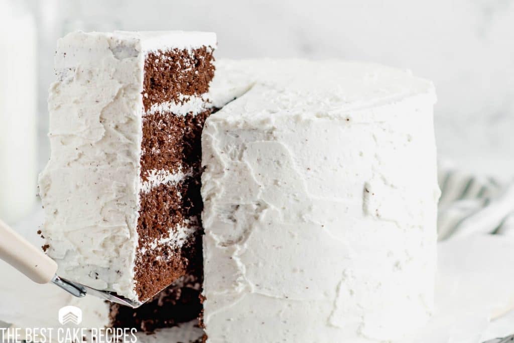 a piece of chocolate cake with white frosting on a spatula