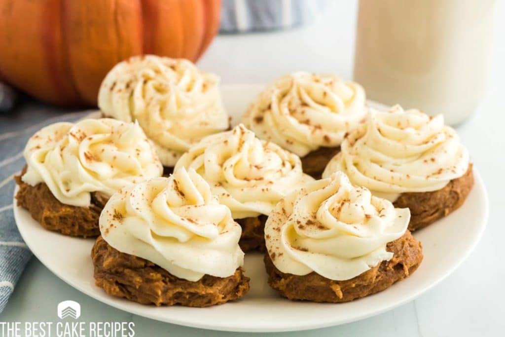 a plate of frosted pumpkin cookies