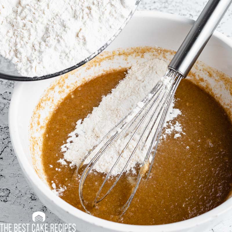 flour pouring in a bowl with cake batter