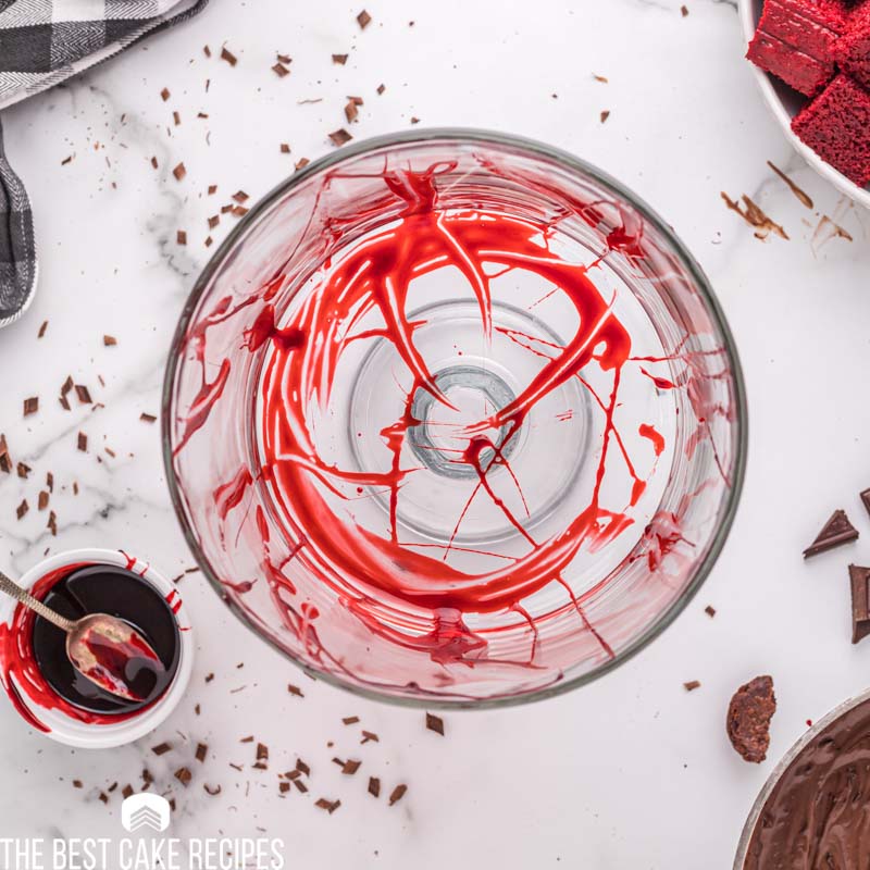 spreading red food color in a glass dish to look like blood