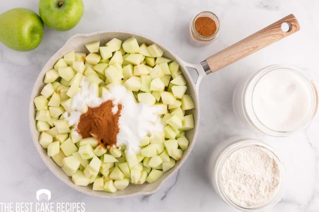 chopped apples in a skillet with sugar and cinnamon