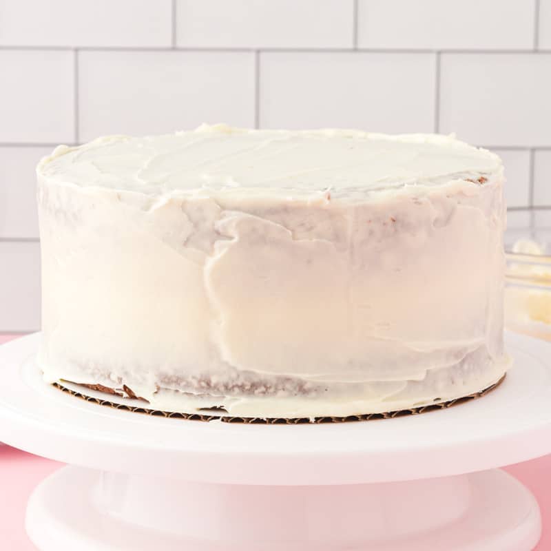 a layer cake with a white crumb coat frosting