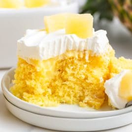 closeup of a piece of pineapple poke cake on a plate