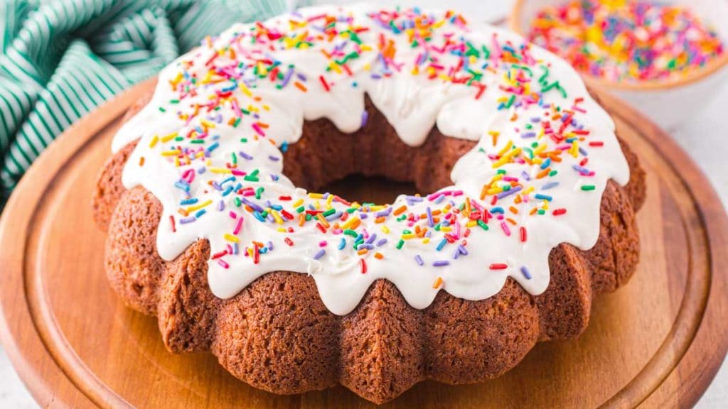 bundt cake with vanilla icing and sprinkles on a plate