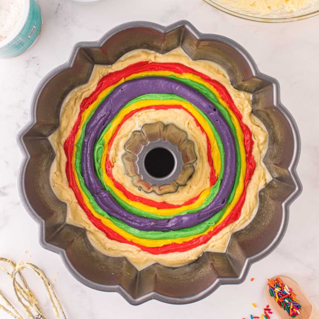 rainbow swirled cake batter in a bundt pan