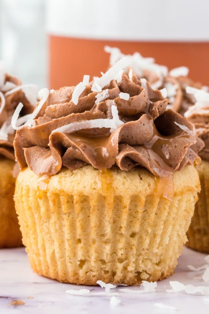 closeup of a cupcake with chocolate frosting, caramel and coconut