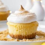 a lemon meringue cupcake on table with graham cracker crumbs