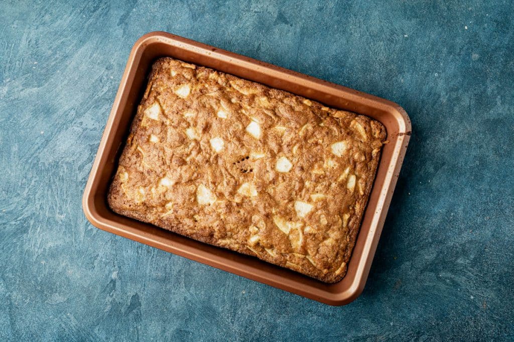 overhead view of baked apple walnut snack cake in a cake pan