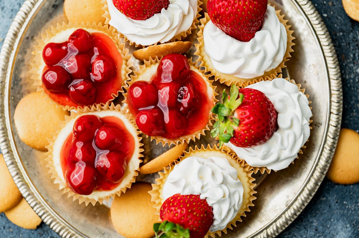 overhead view of mini cheesecake cups with strawberries and cherries