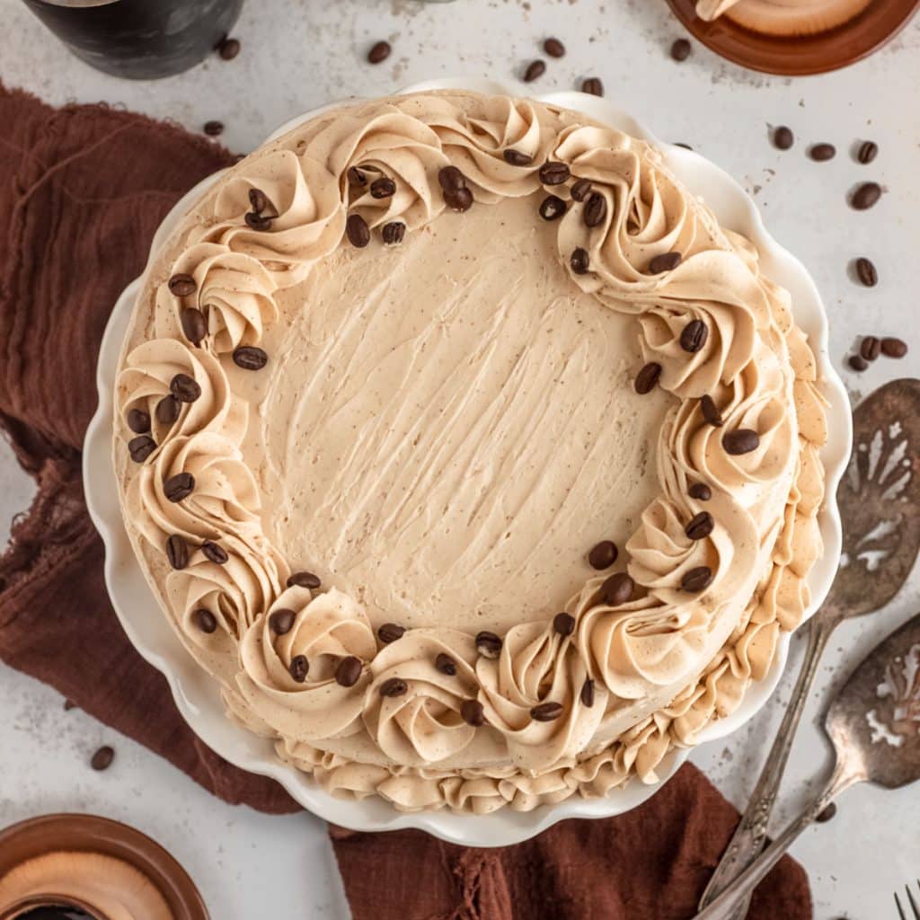 overhead view of a chocolate espresso cake with frosting swirls and coffee beans