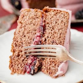 a piece of blackberry jam spice cake on a plate with a fork