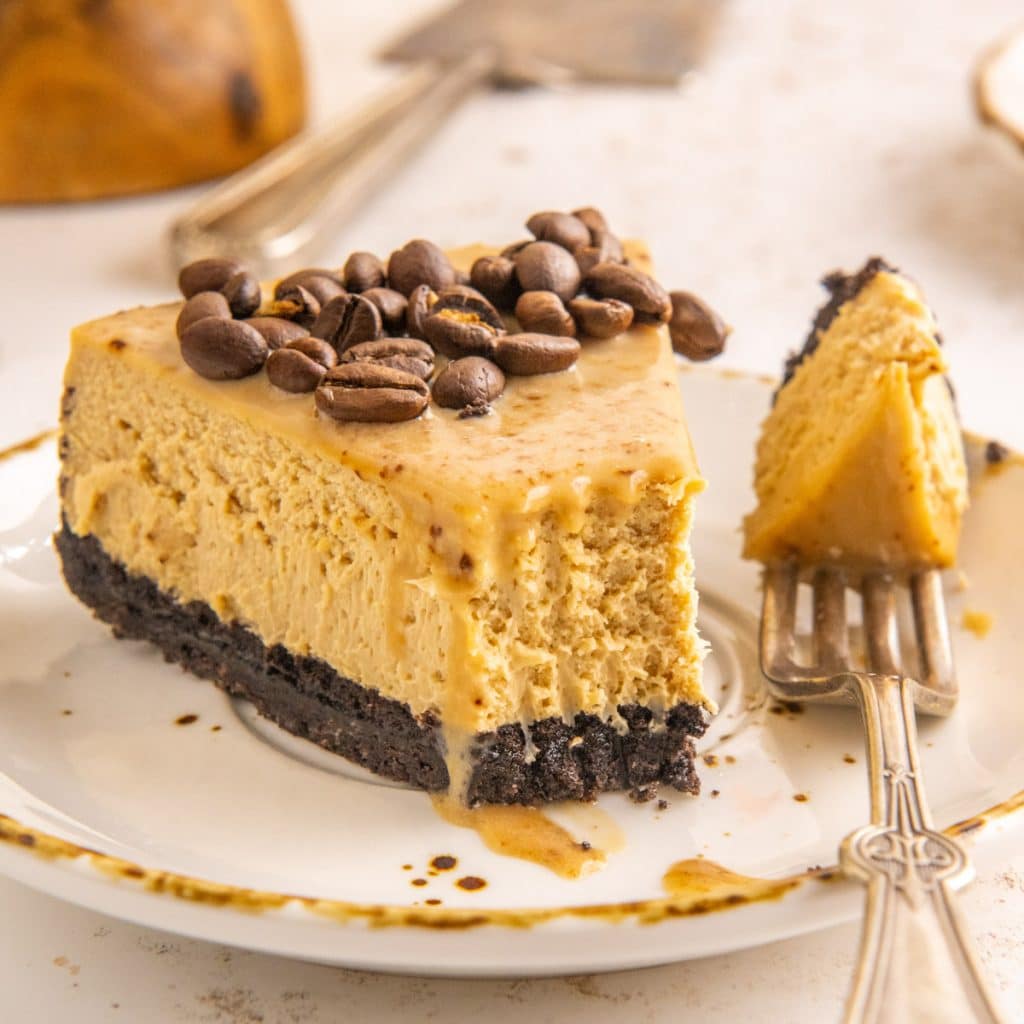 a piece of coffee cheesecake on a plate with a fork