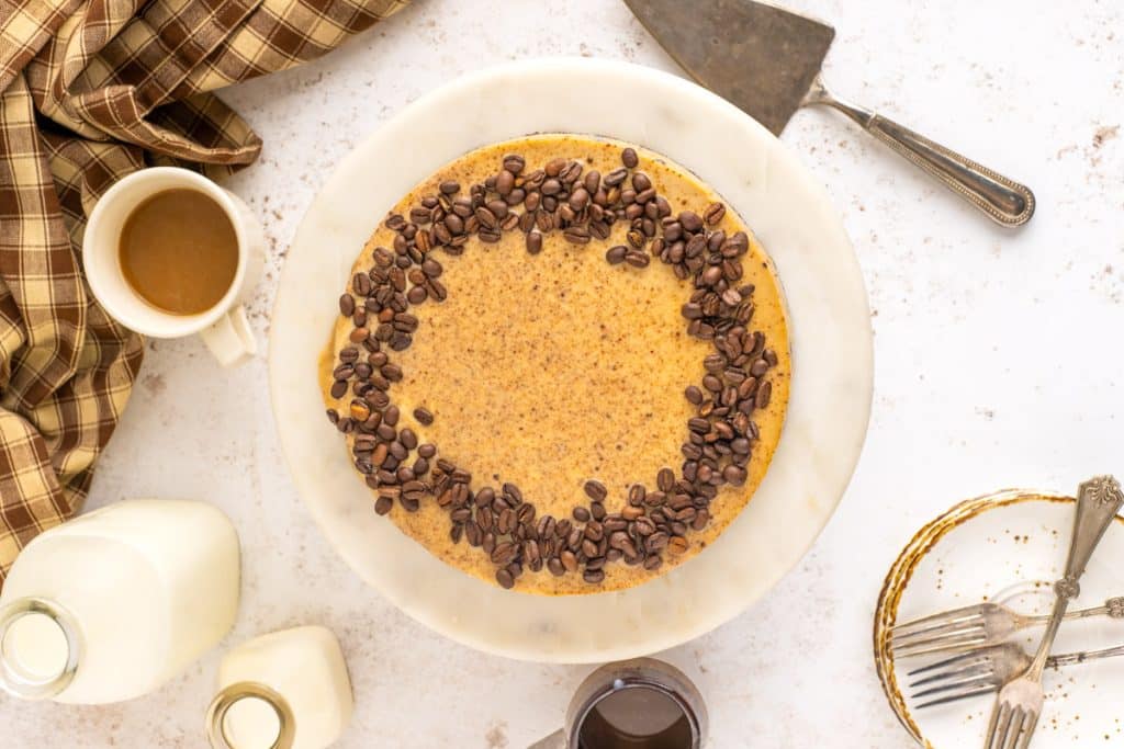 overhead view of a cheesecake with coffee beans on top sitting on a table