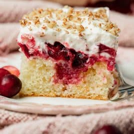 a slice of cranberry poke cake on the table