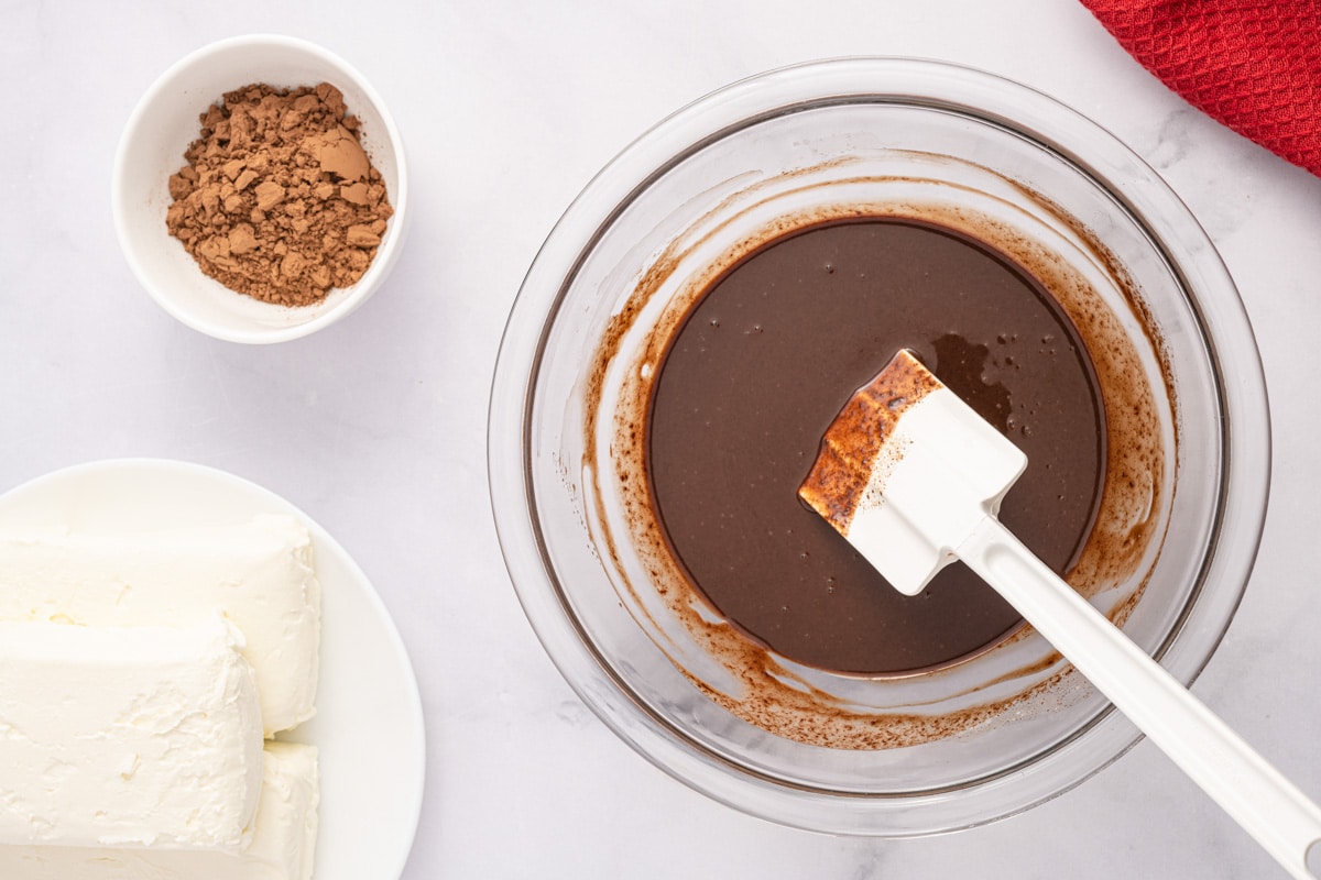 melted chocolate in a glass bowl with a rubber spatula