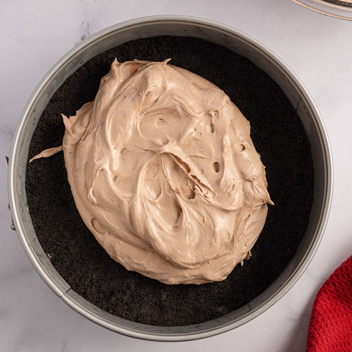 fluffy chocolate cheesecake filling dolloped on an oreo crust