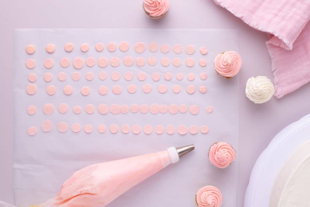 frosted cupcakes and icing decorations on a table