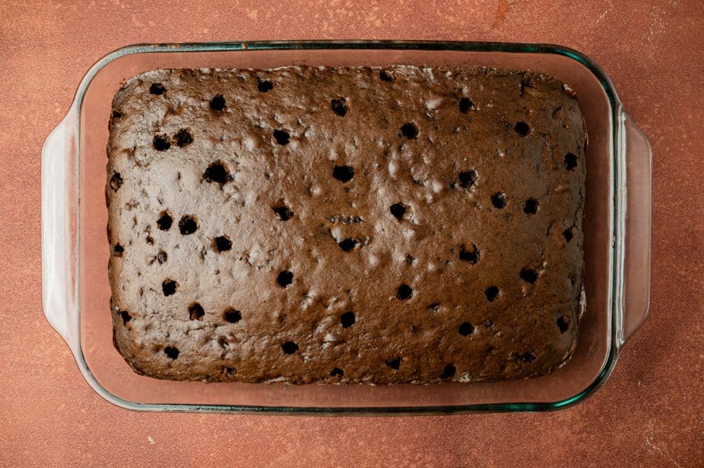 chocolate cake showing holes poked in it