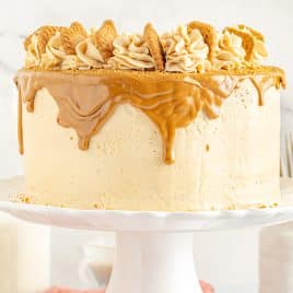 whole iced cake with caramel drizzle, frosting swirls and biscoff cookies as decoration