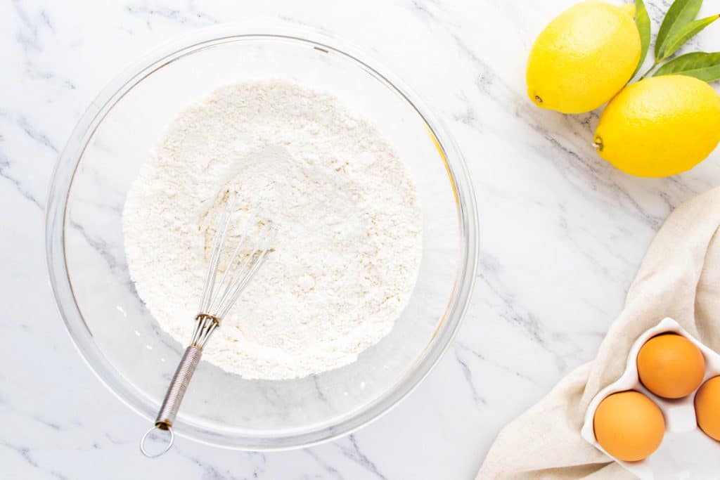 flour in a glass bowl with a whisk
