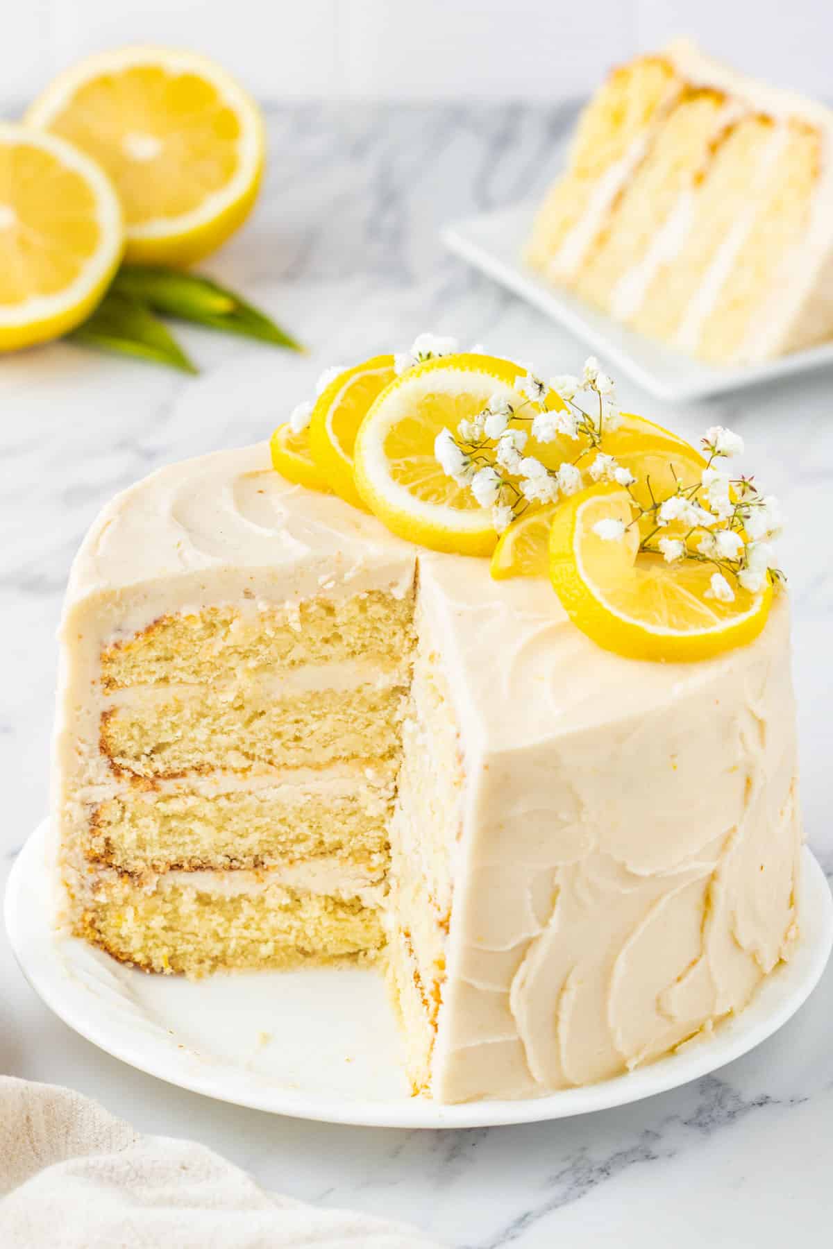 a lemon cake with cream cheese frosting on a plate with a slice out