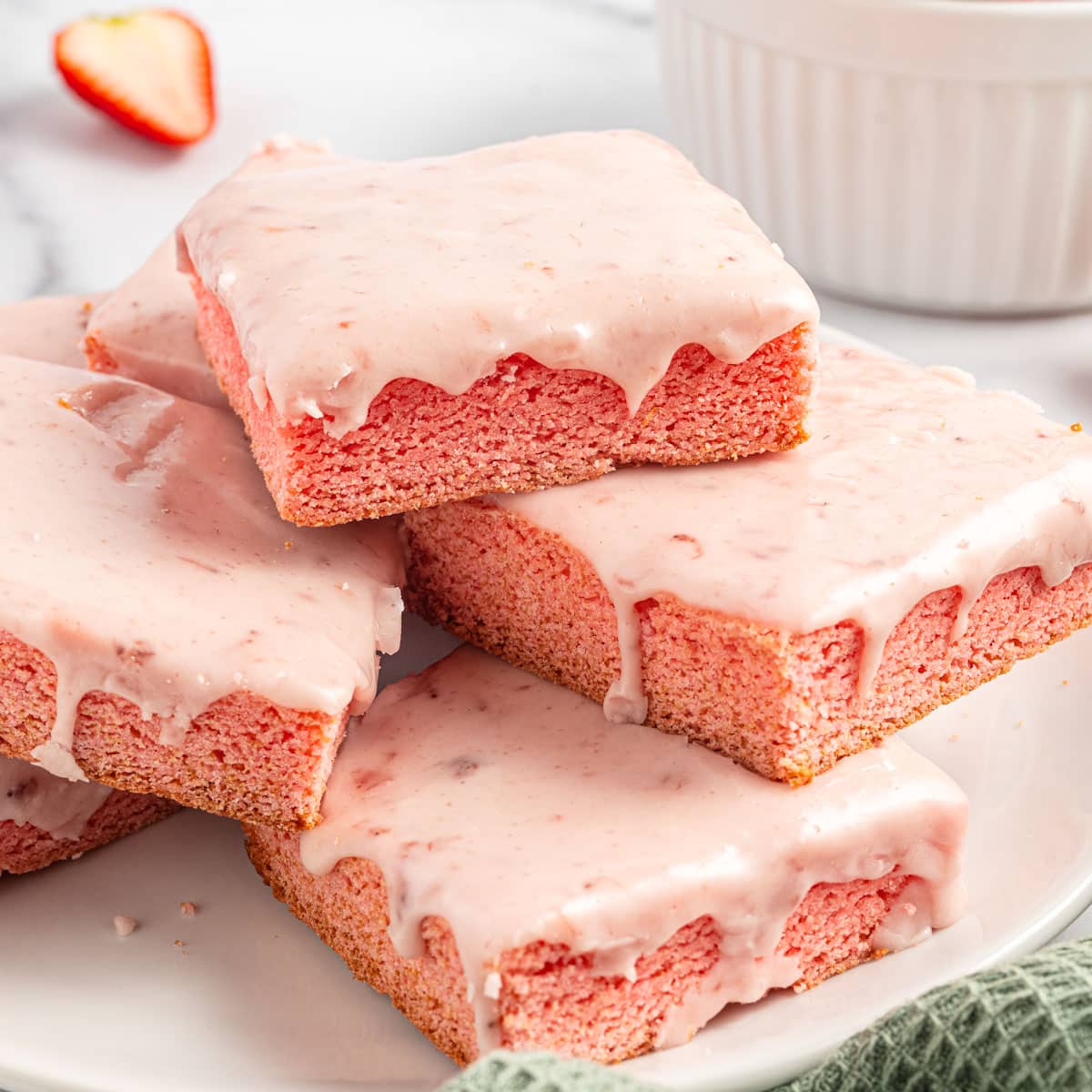 a stack of strawberry brownie bars with strawberry jam glaze